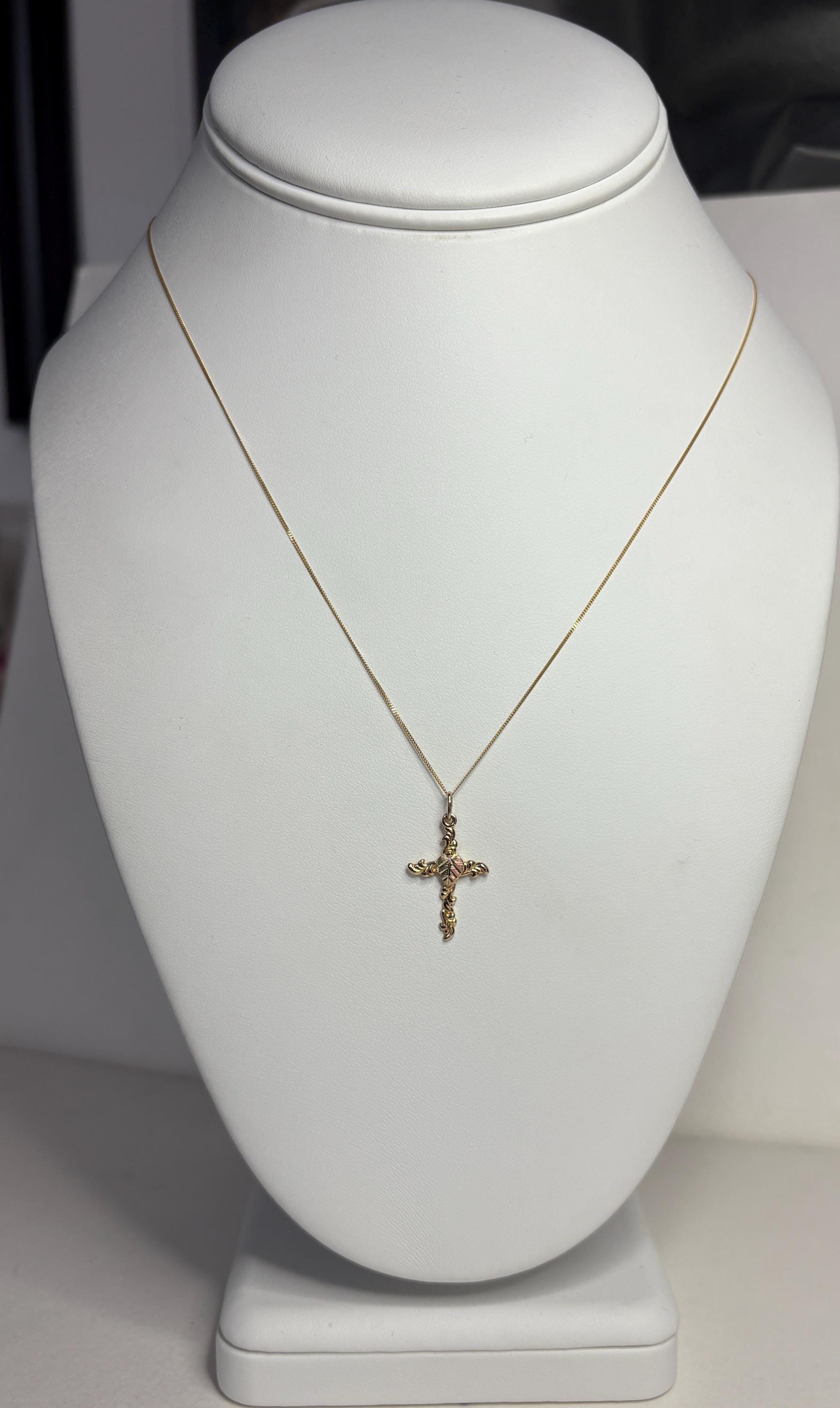 Black Hills Gold tri-color gold cross pendant on an 18-inch 9k gold chain.