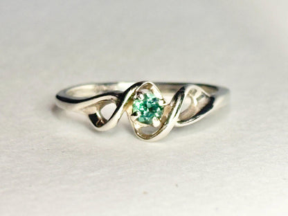A 10k white gold band ring with a natural blue-green tourmaline.