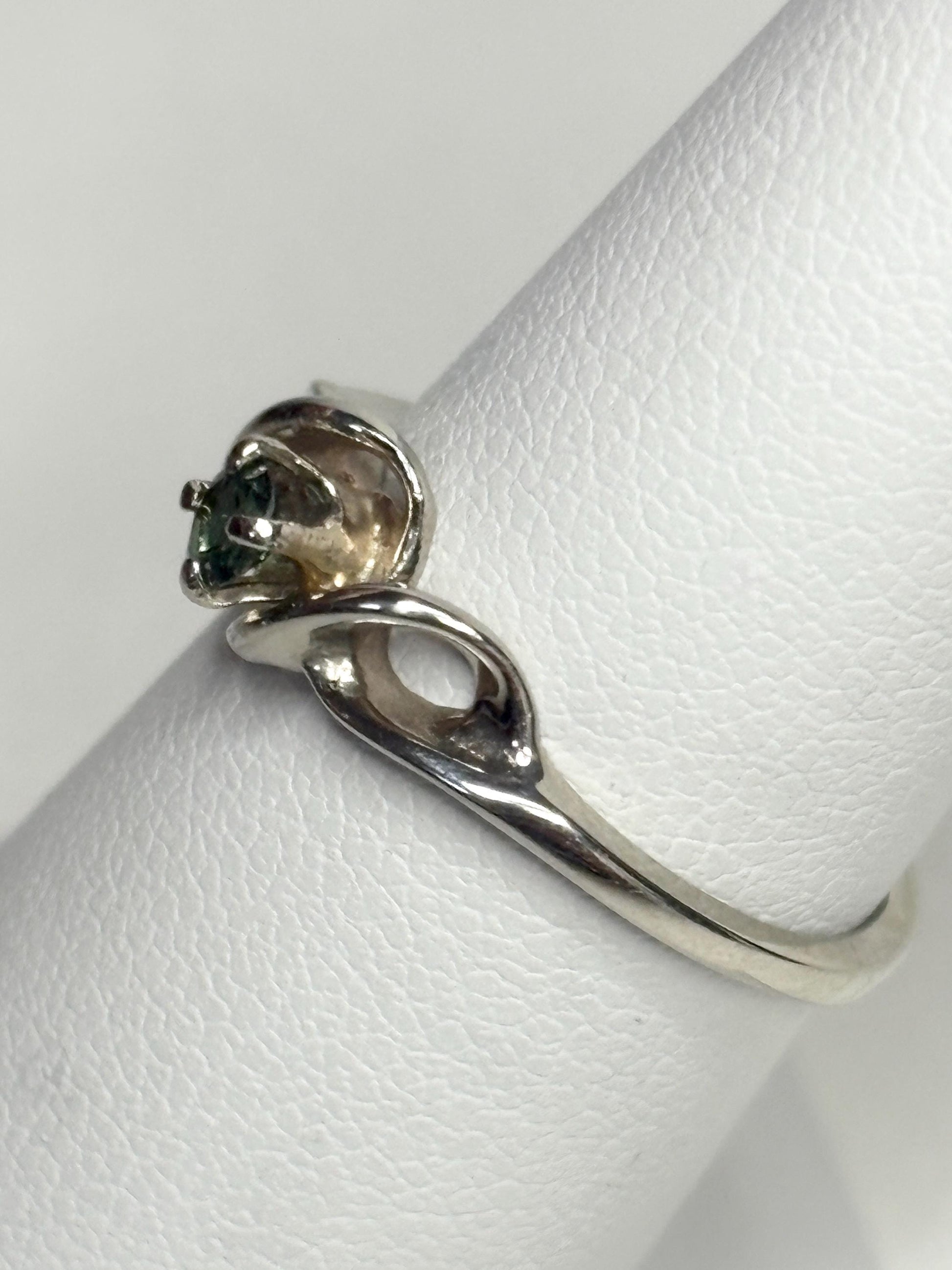 A solid 10k white gold band ring with a natural blue-green tourmaline.