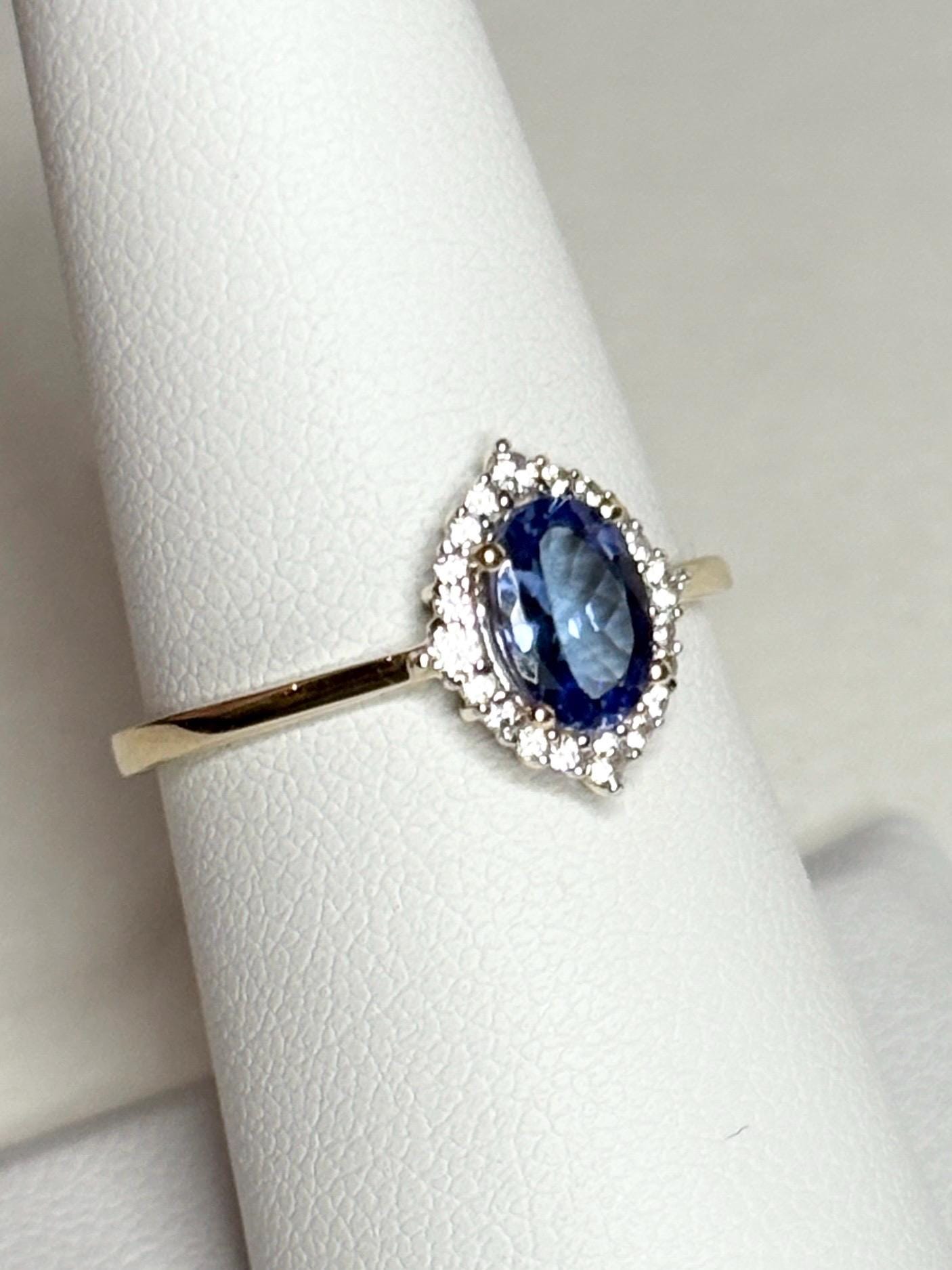 Oval tanzanite and zircon halo ring in solid 9k gold.