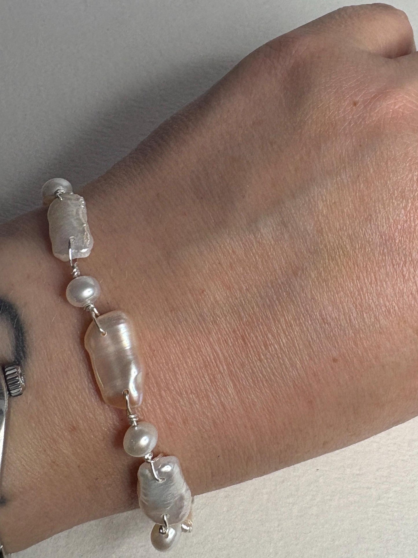 Sterling silver bracelet with irregular white and peach Biwa pearls.