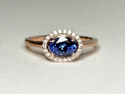 Oval tanzanite and diamond halo ring in 14k rose gold.
