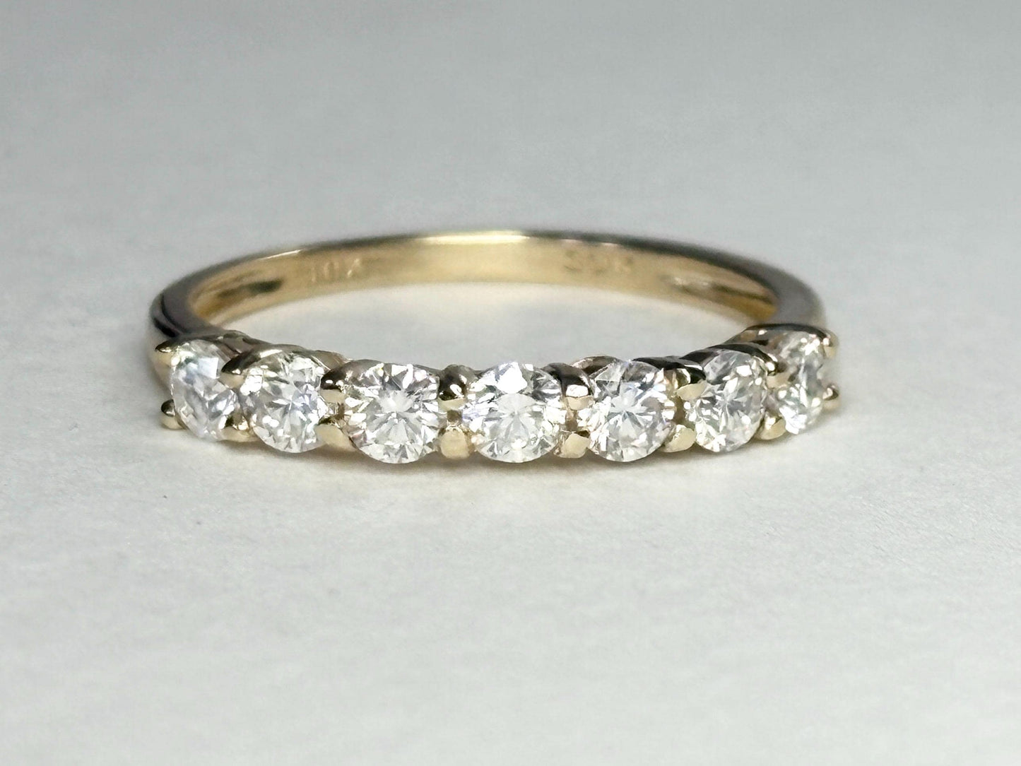 Solid 10k gold band ring with seven moissanite stones.