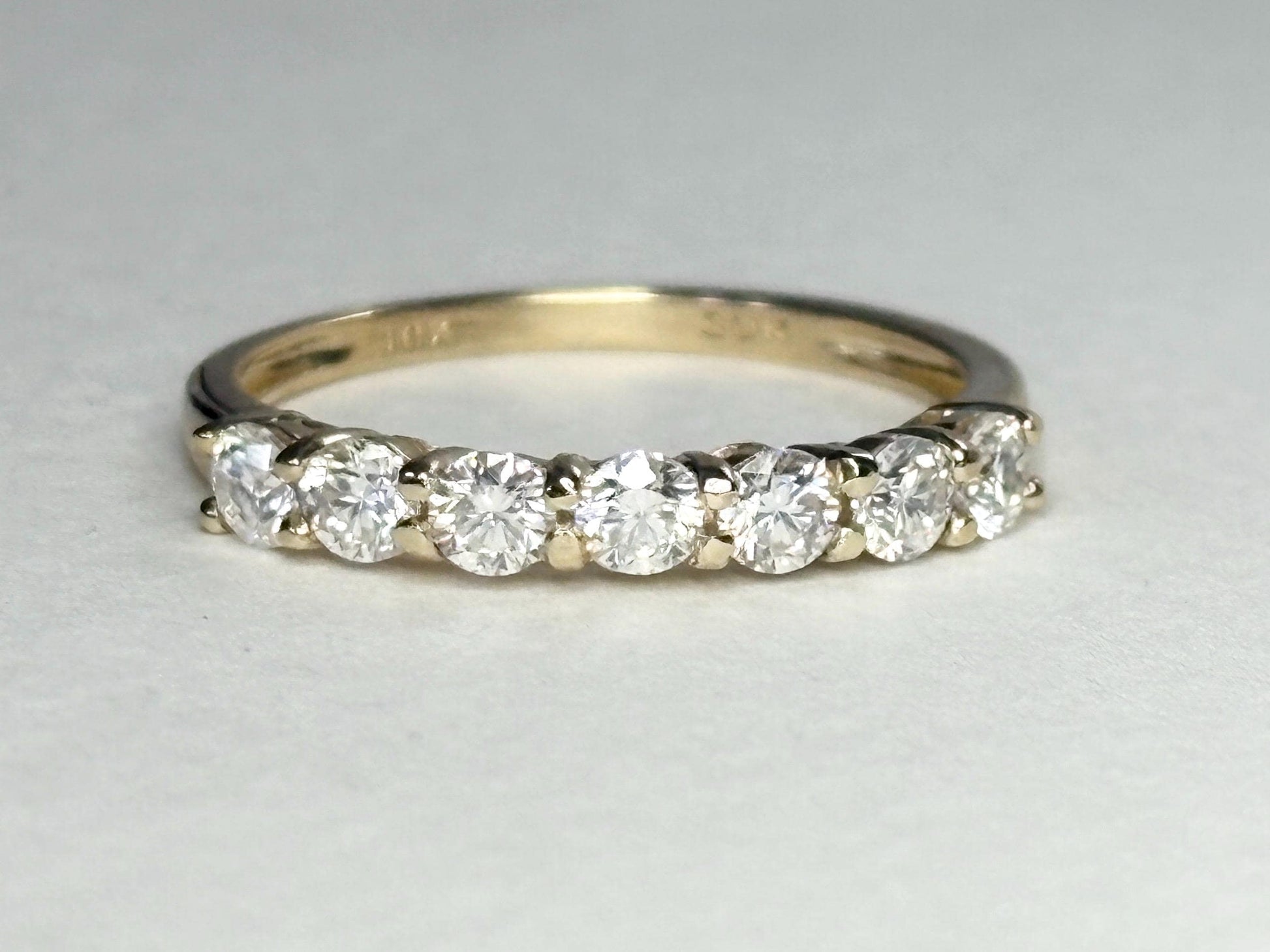 Solid 10k gold band ring with seven moissanite stones.