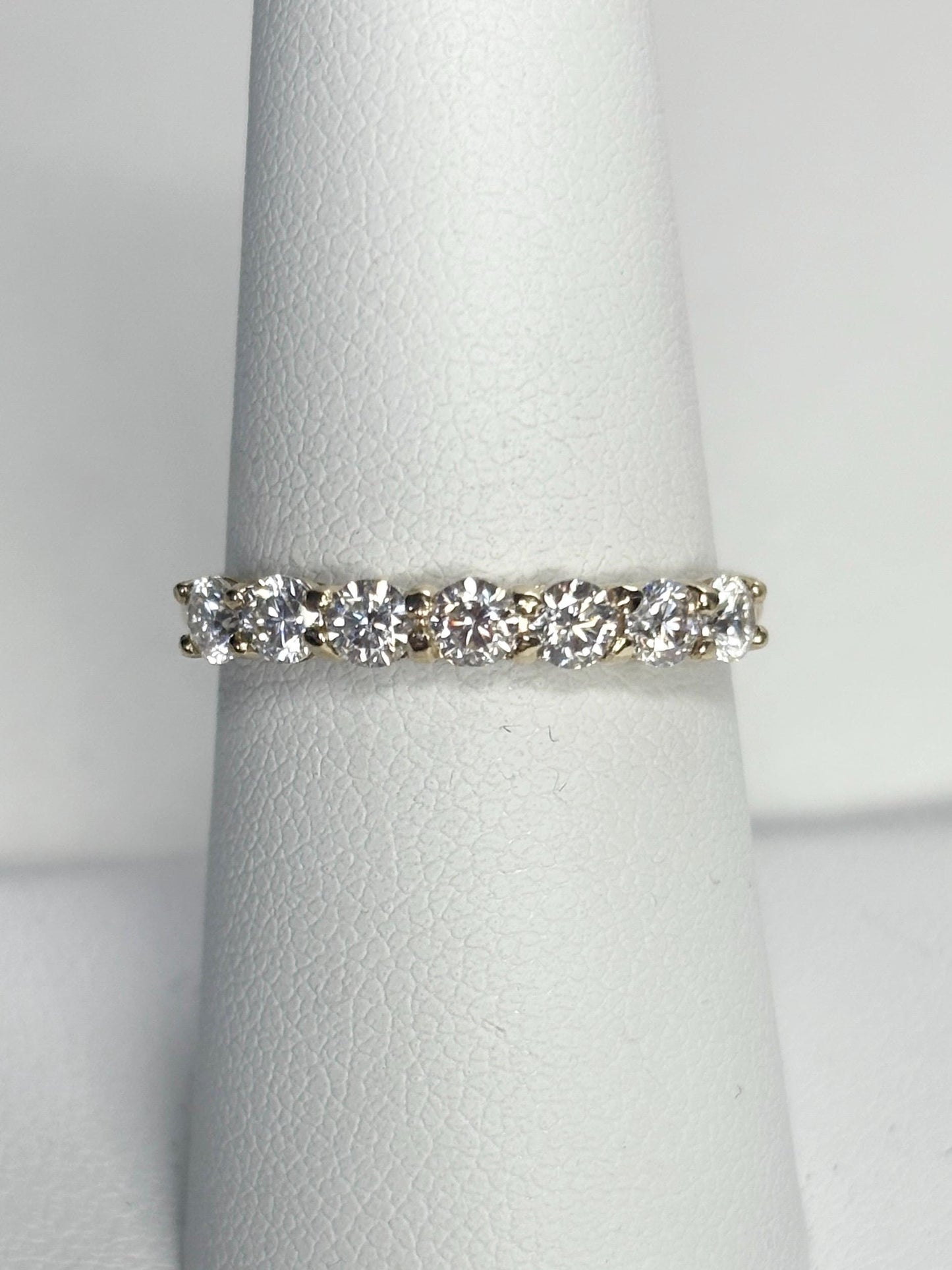 Solid 10k gold band ring with seven moissanite stones.