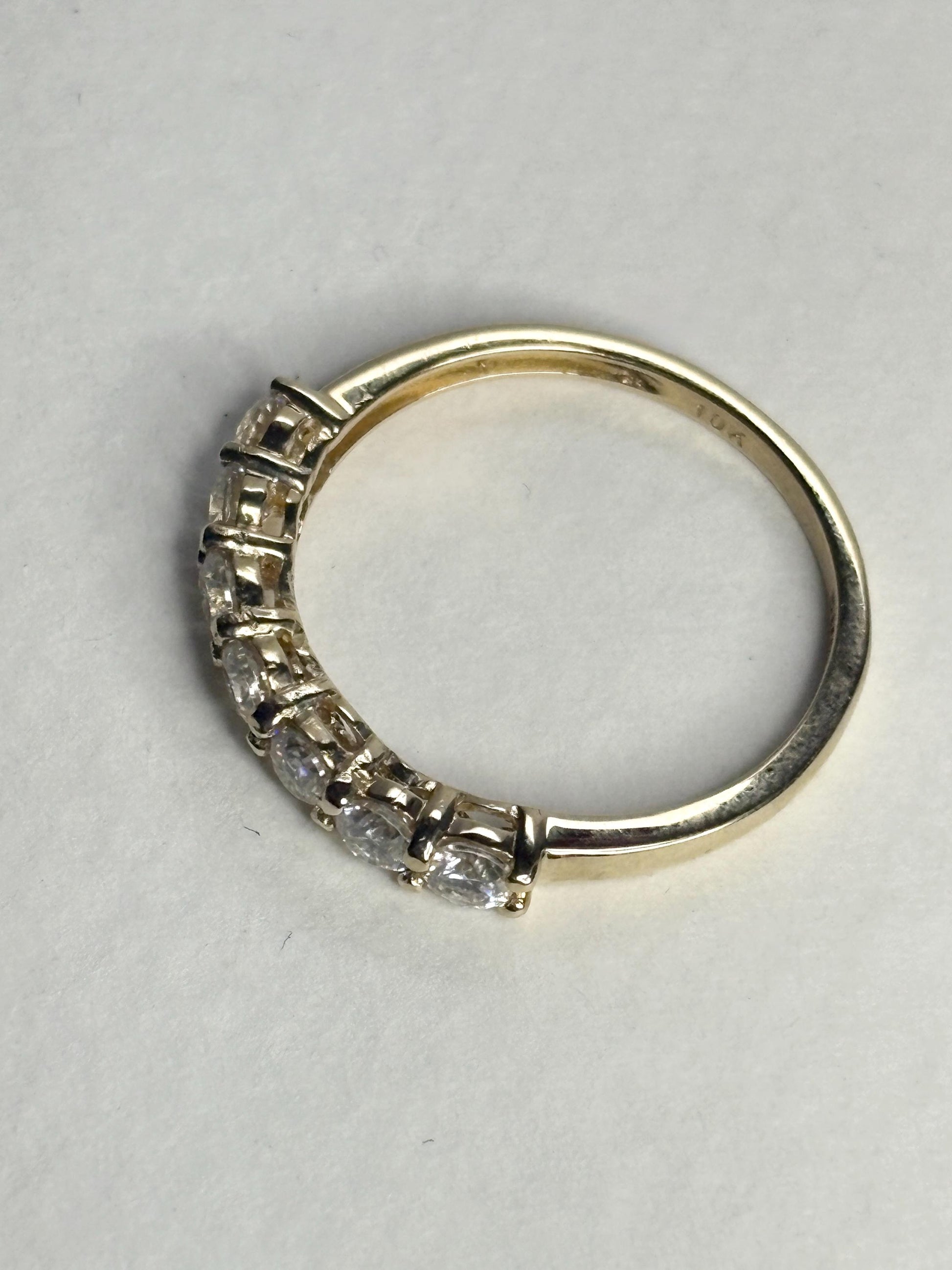 Solid 10k yellow gold band ring with seven moissanite stones.