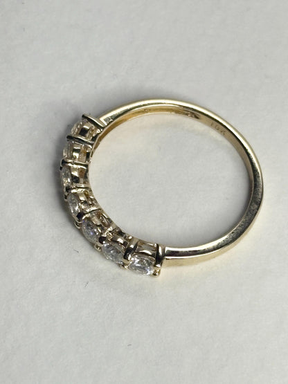 Solid 10k yellow gold band ring with seven moissanite stones.