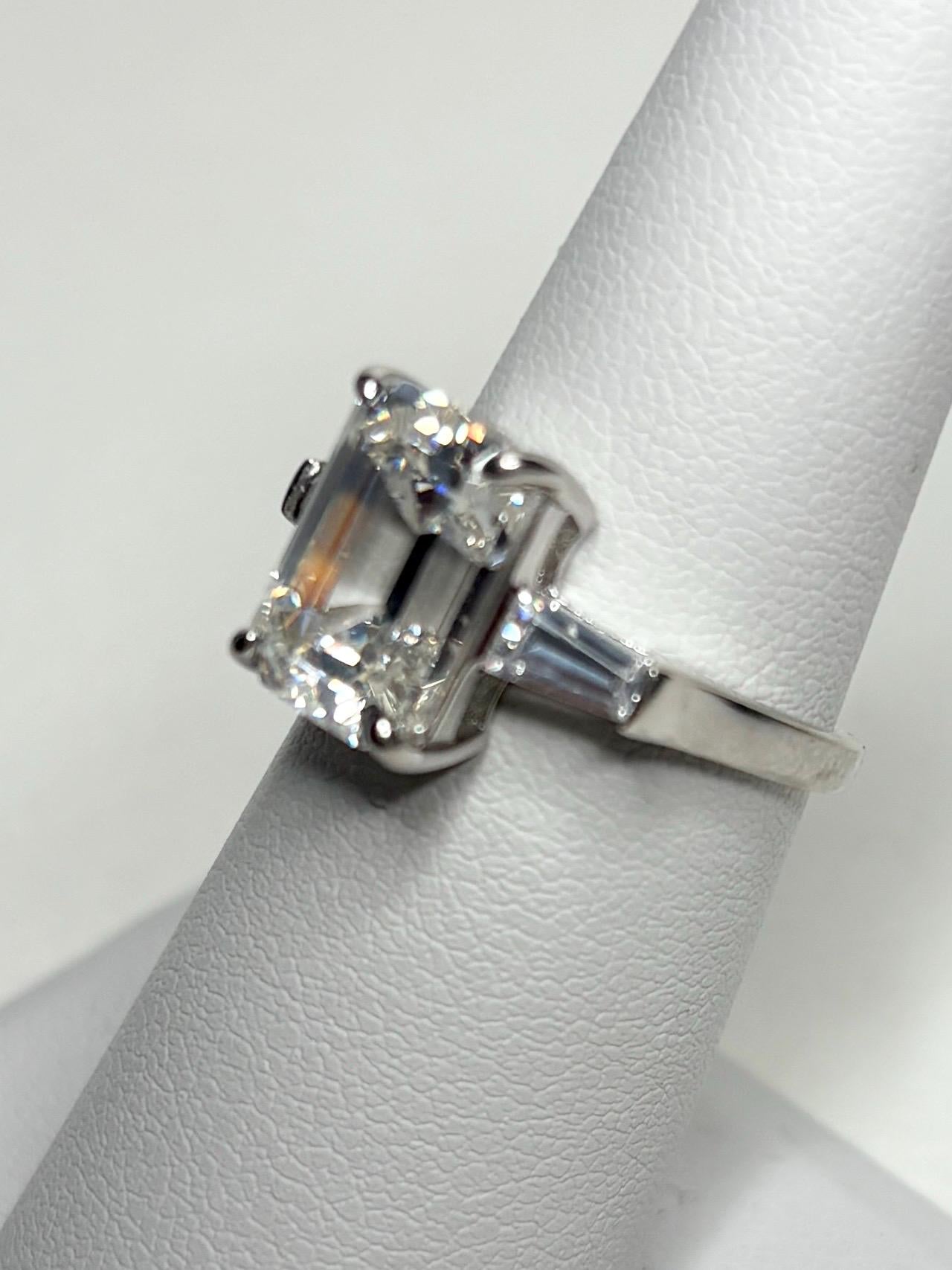 Sterling silver ring with a large emerald-cut cubic zirconia and two baguette side stones.