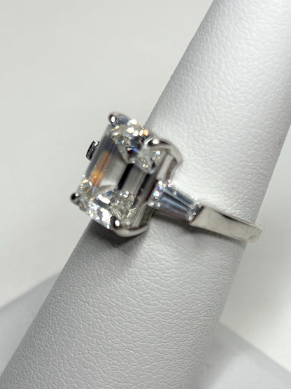 Sterling silver ring with a large emerald-cut cubic zirconia and two baguette side stones.