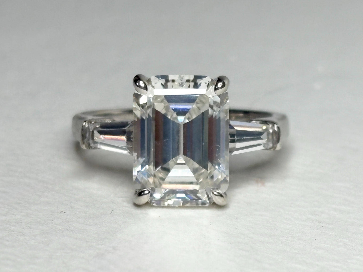 Sterling silver ring with a large emerald-cut cubic zirconia and two baguette side stones.
