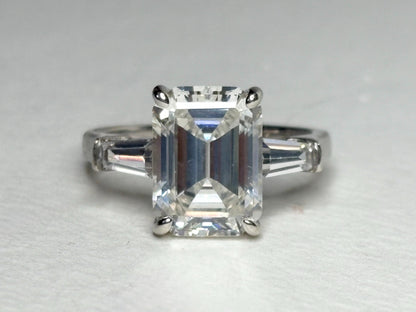 Sterling silver ring with a large emerald-cut cubic zirconia and two baguette side stones.