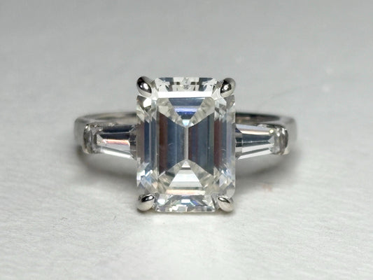 Sterling silver ring with a large emerald-cut cubic zirconia and two baguette side stones.