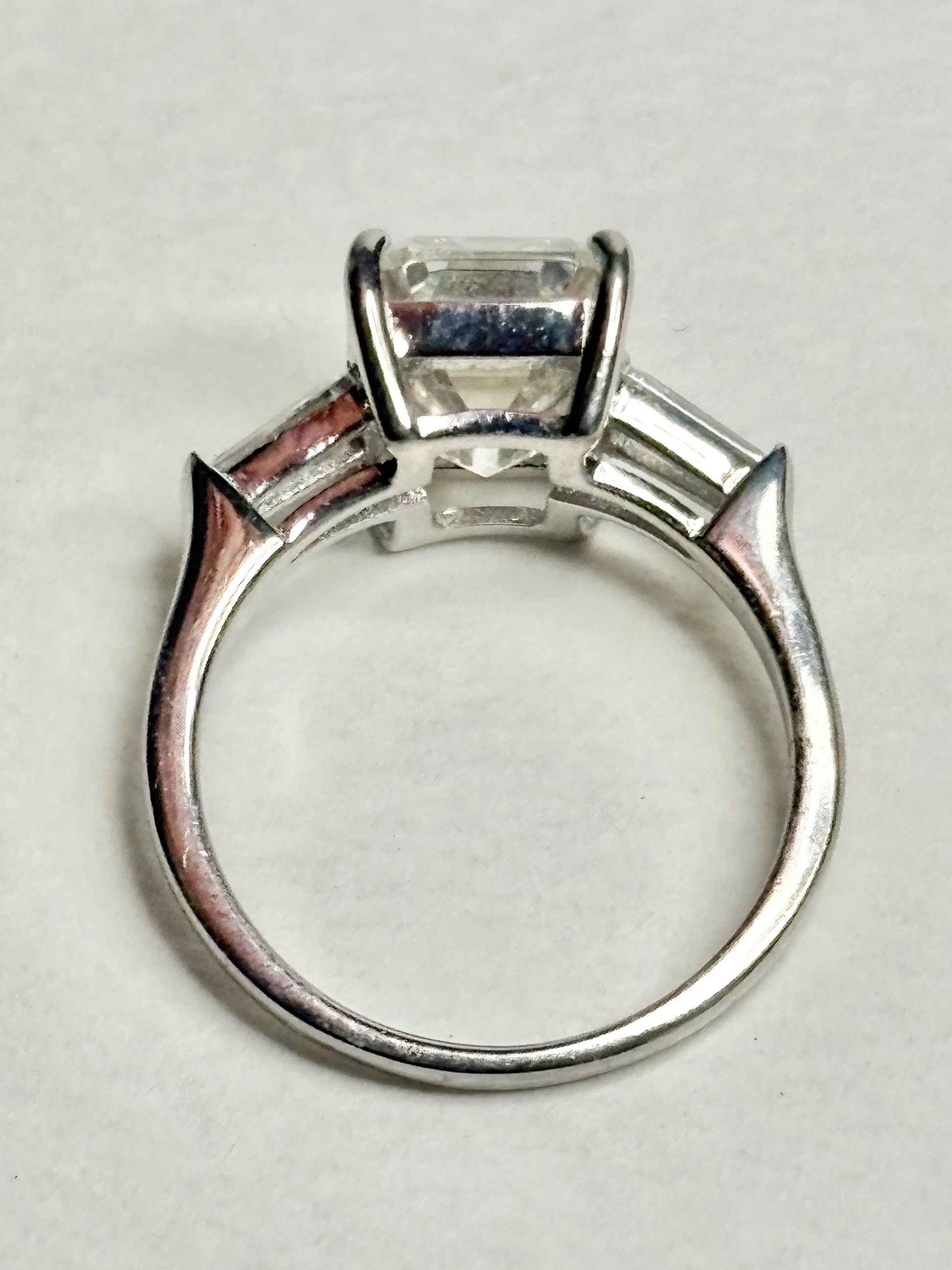 Sterling silver ring with an emerald-cut cubic zirconia and two baguette side stones.