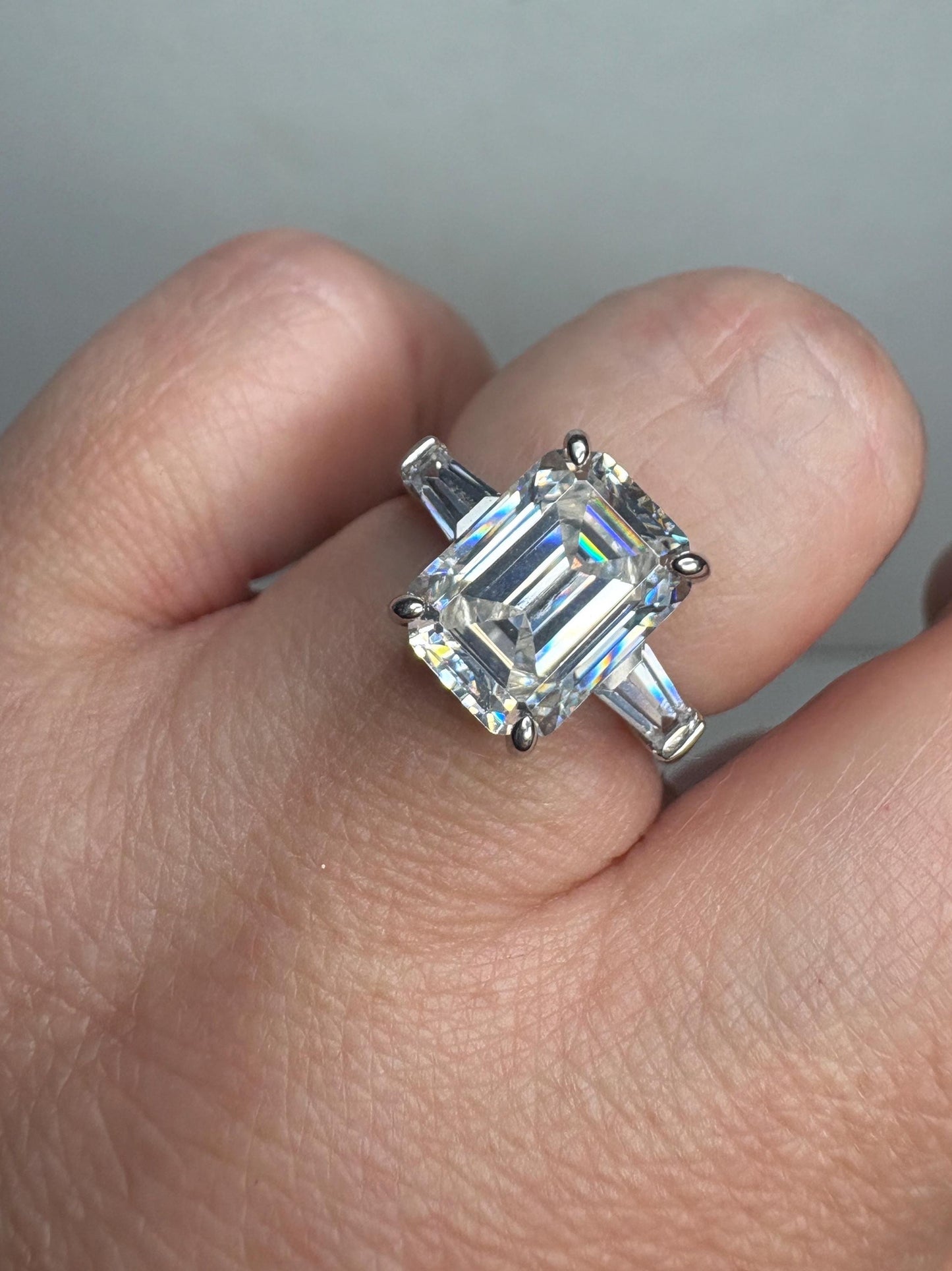 Sterling silver ring with a large emerald-cut cubic zirconia and two baguette side stones.