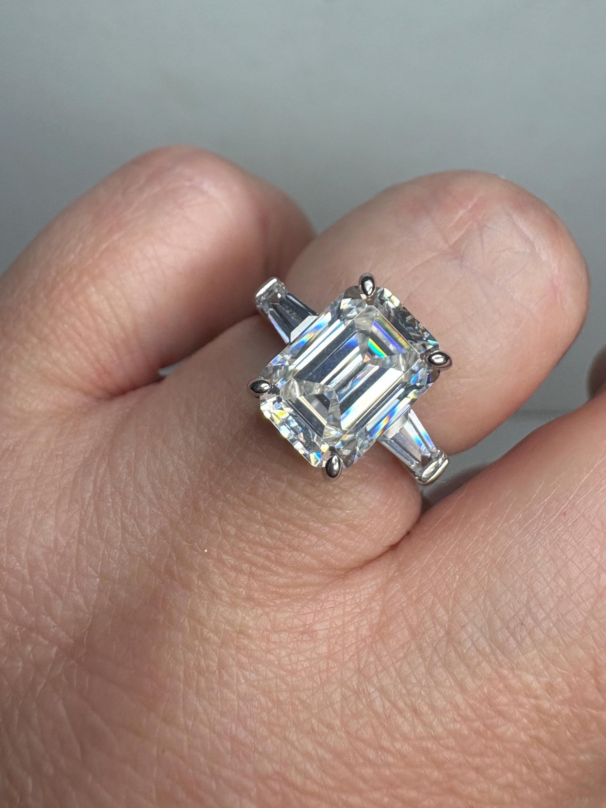 Sterling silver ring with a large emerald-cut cubic zirconia and two baguette side stones.