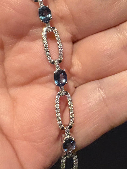 A 14k white gold bracelet with oval alexandrite stones and diamond accents.