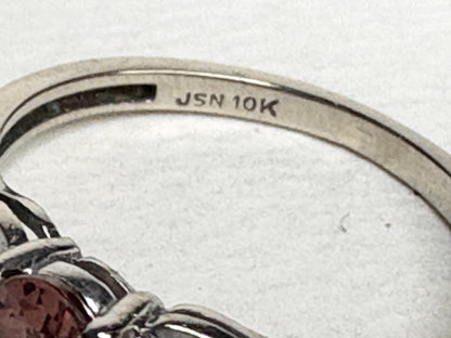 A 10k white gold ring with a pink zircon and diamond accents.