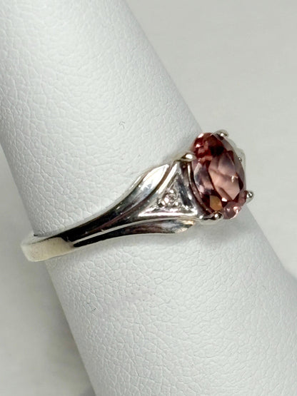 A 10k white gold ring with a blush pink zircon and diamond accents.