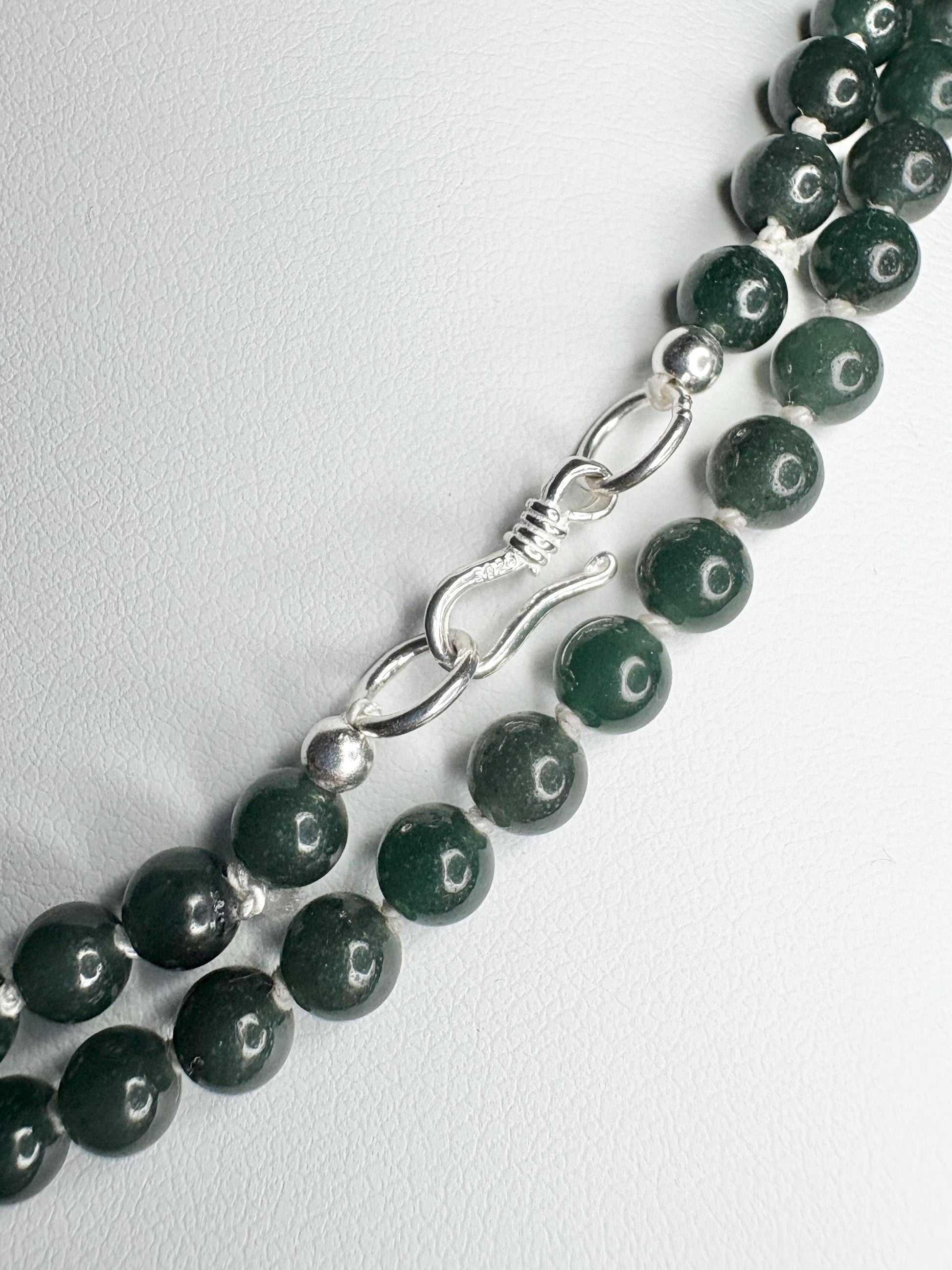 Teal jadeite jade beads with a sterling silver clasp.