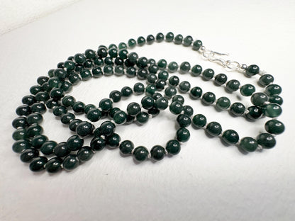 A long teal jadeite jade beaded necklace with a sterling silver clasp.