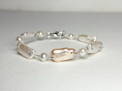 Sterling silver bracelet with irregular white and peach freshwater pearls.