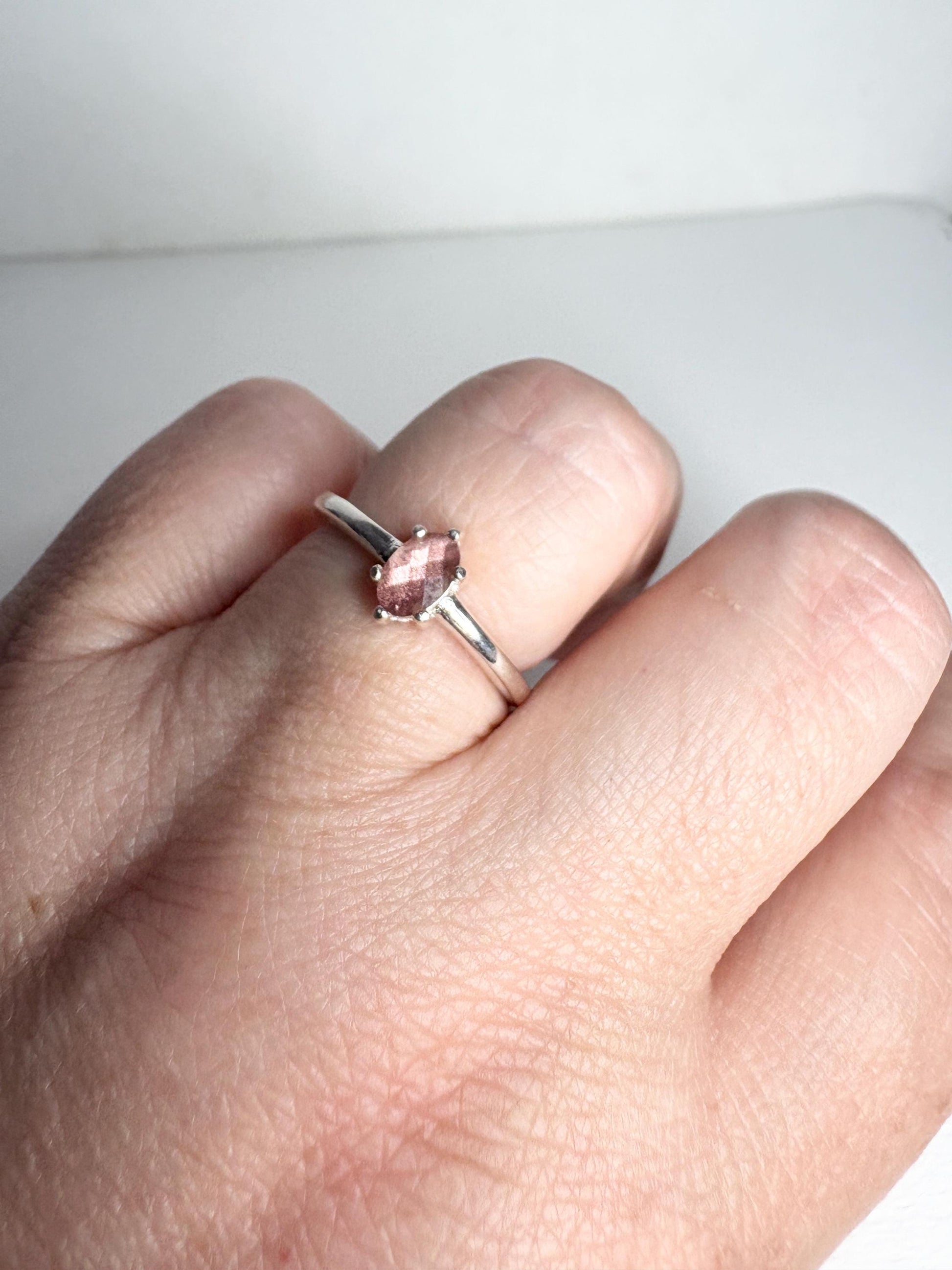 Sterling silver ring with a faceted oval Oregon Sunstone.
