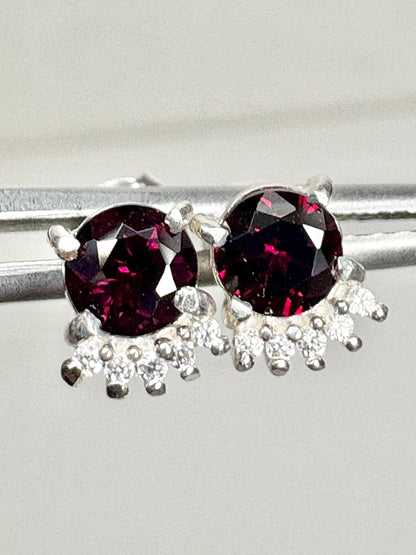 Sterling silver stud earrings with round garnets and small white zircons.