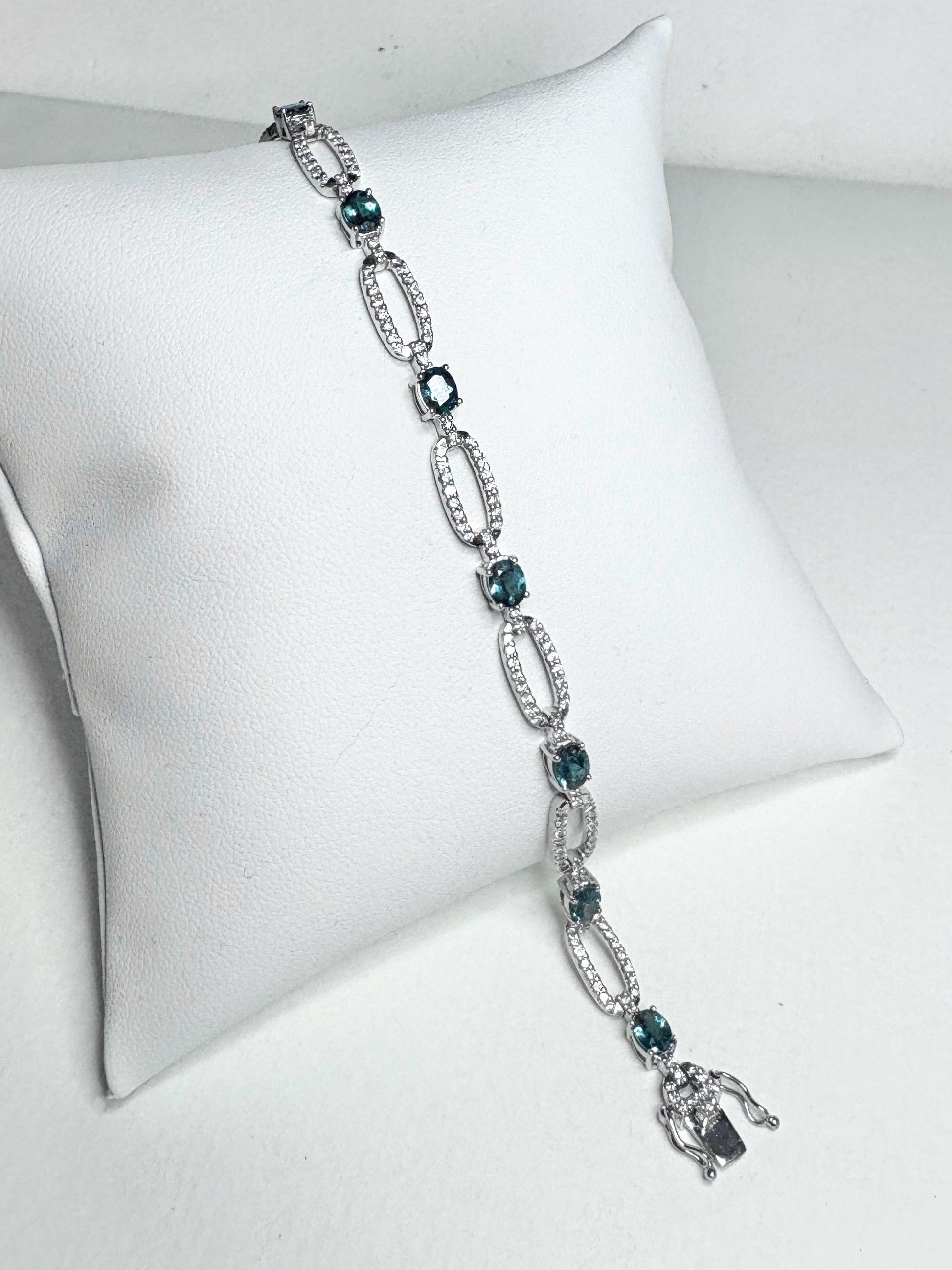 A white gold bracelet with oval alexandrite stones and diamonds.