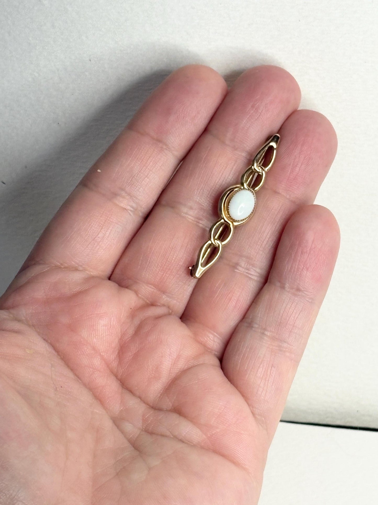 14k gold bar brooch with a white opal.