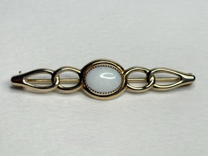 14k gold bar brooch with a white opal center.