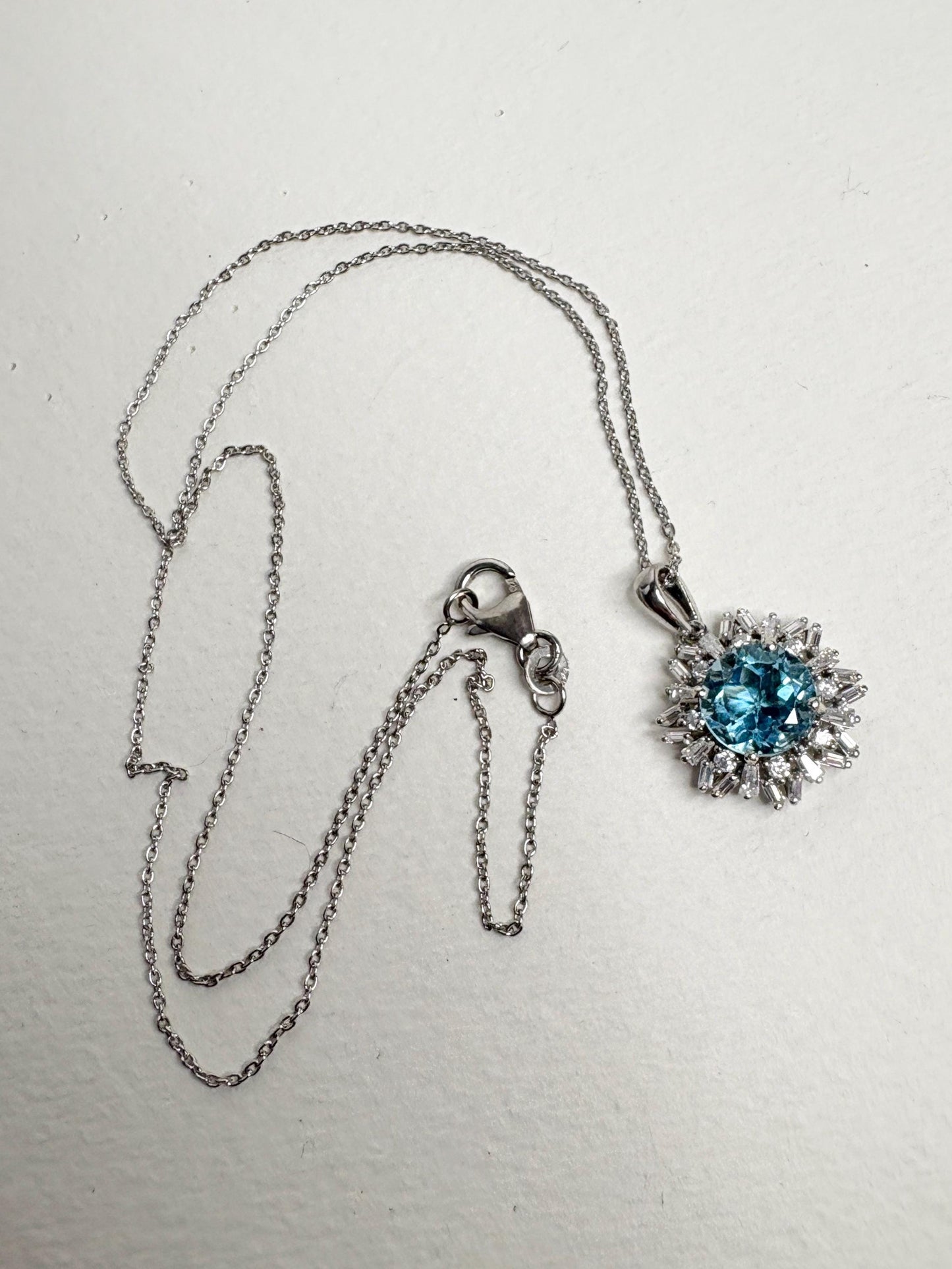 Sterling silver pendant necklace with blue topaz and moissanite.