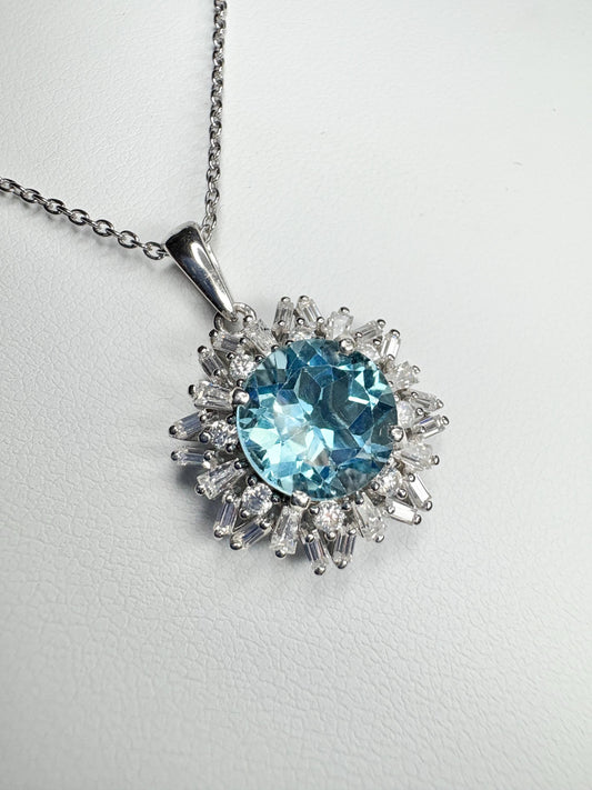 Sterling silver pendant necklace with a blue topaz center and moissanite halo.