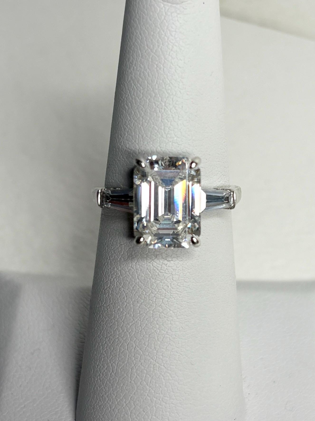 Sterling silver ring with a large emerald-cut cubic zirconia and two baguette side stones.