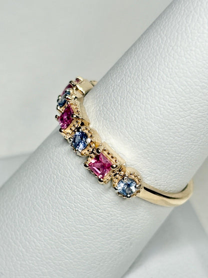A 9k gold band ring with pink and violetish-blue sapphires.
