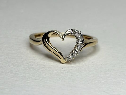 A 10k yellow gold ring with a heart design featuring eight small diamonds.