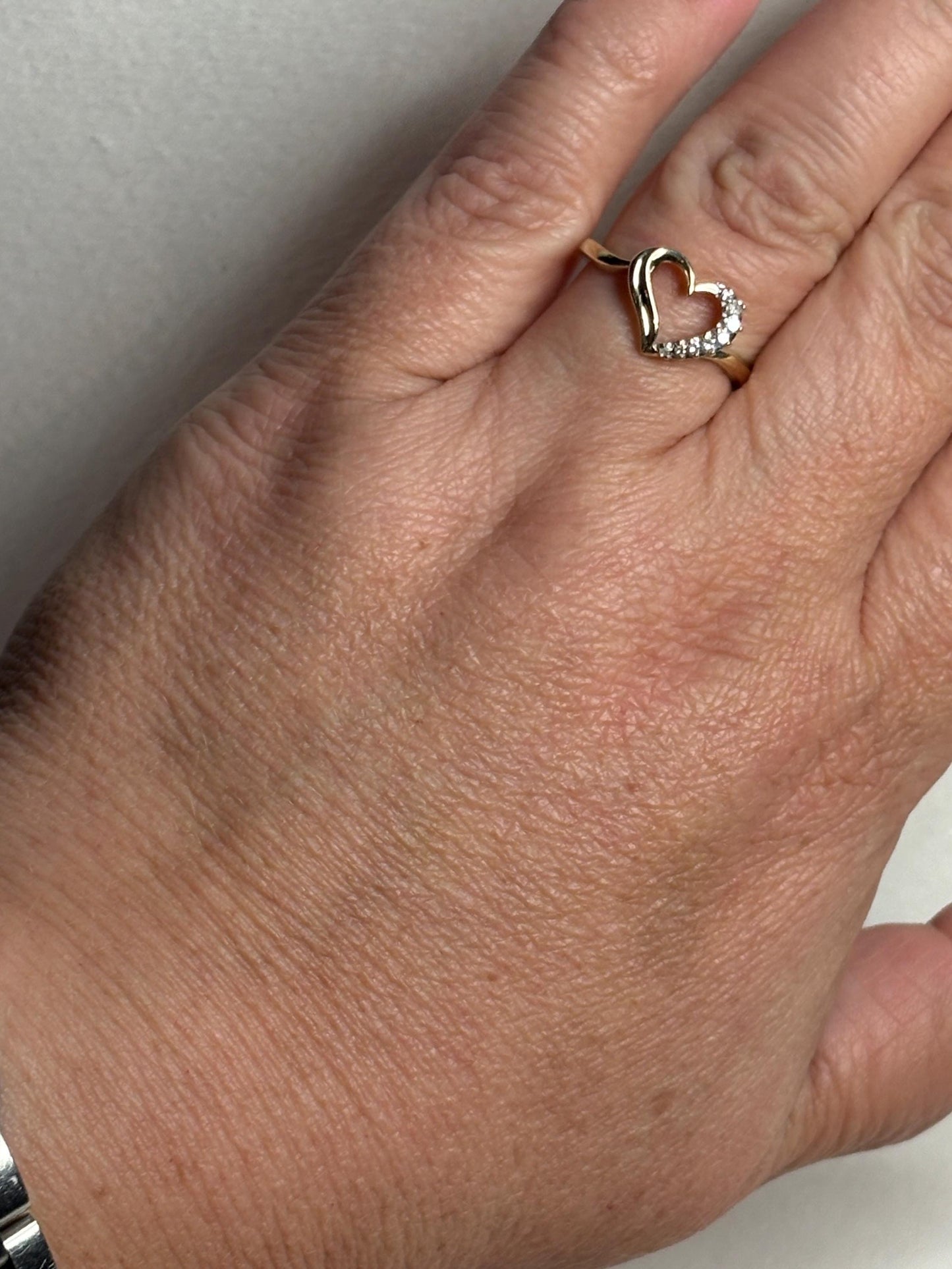 A 10k yellow gold ring with a heart shape and diamonds.