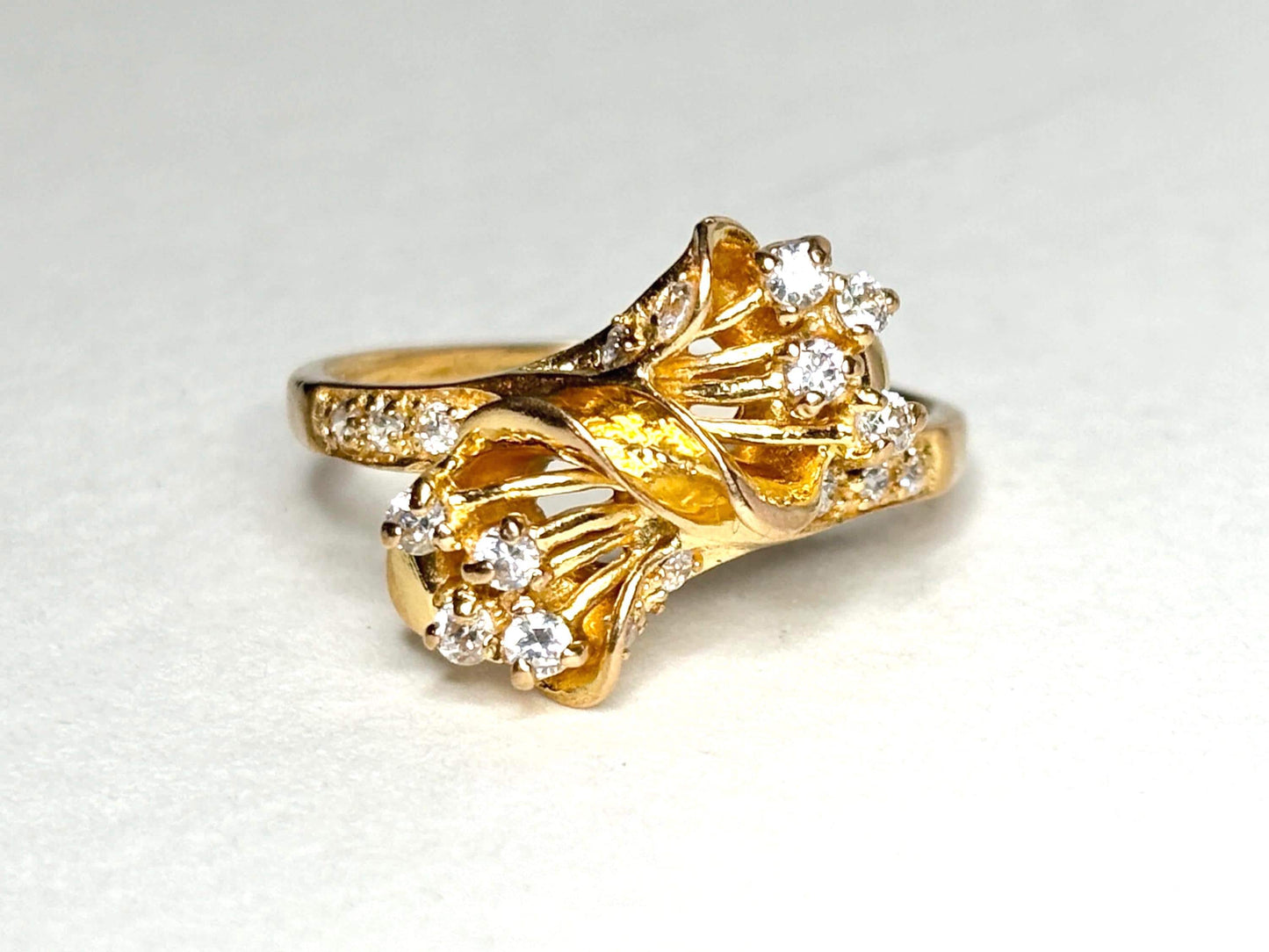 Solid 21k gold bypass ring with white stones.