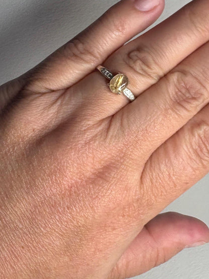 Sterling silver ring with a rutilated quartz center stone and zircon accents.