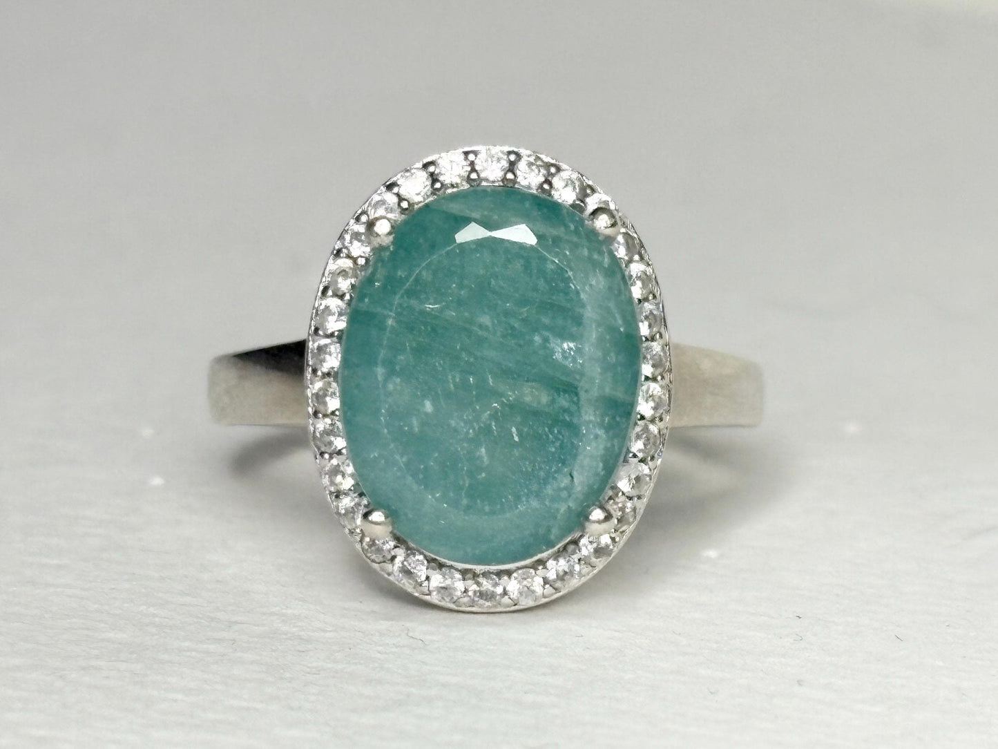 Oval grandidierite ring with zircon halo in sterling silver.