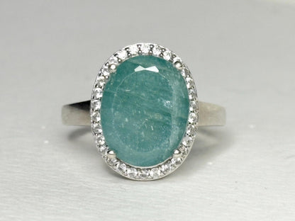 Oval grandidierite ring with zircon halo in sterling silver.