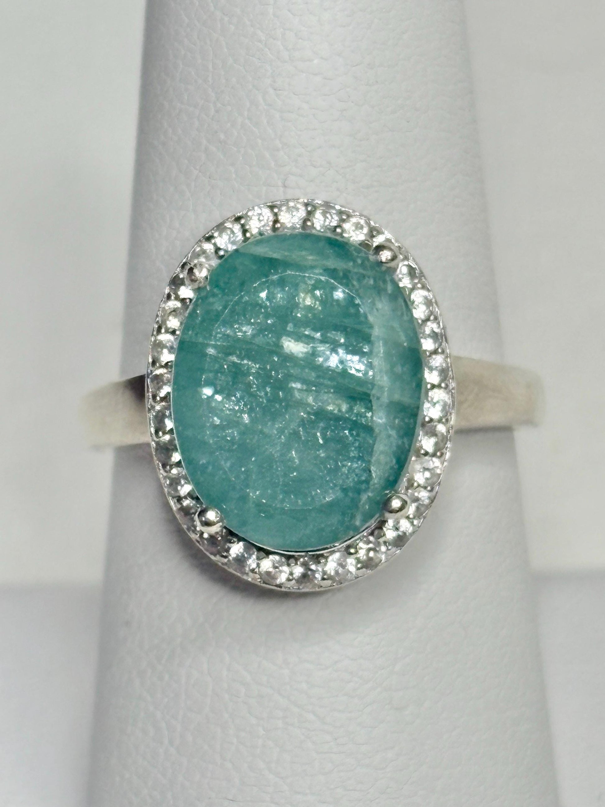 Sterling silver ring with oval grandidierite and zircon halo.