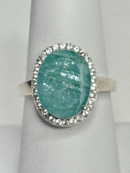 Sterling silver ring with oval grandidierite and zircon halo.