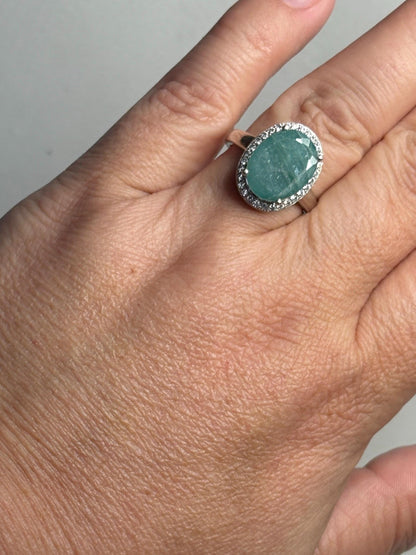 A large oval grandidierite ring with a zircon halo in sterling silver.