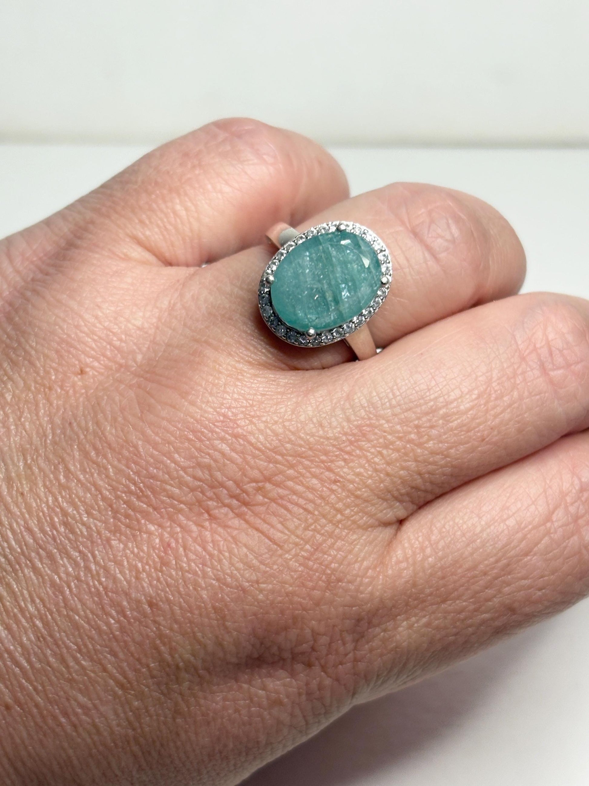 Sterling silver ring with a large oval grandidierite and zircon halo.