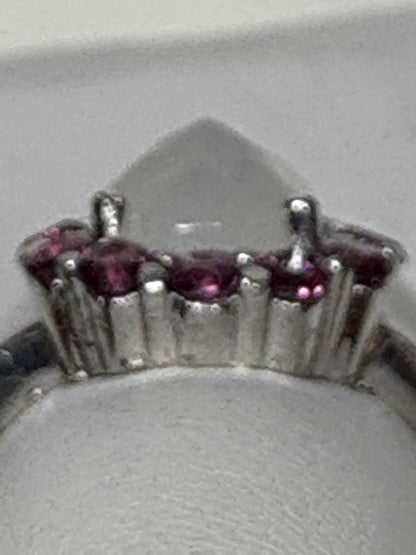 Sterling silver ring with a pear-shaped rainbow moonstone and round rhodolite garnets.