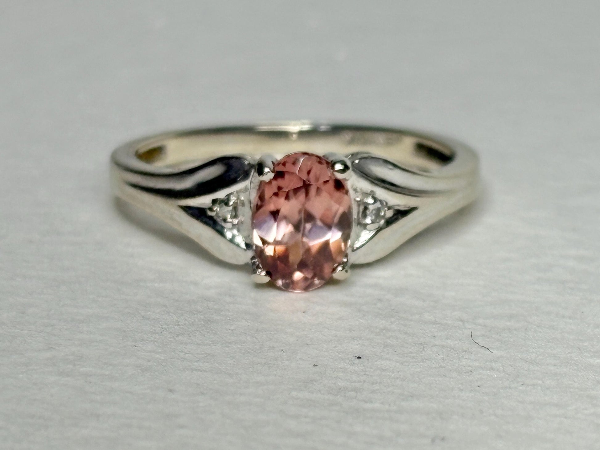 10k white gold ring with a blush pink zircon and diamond accents.