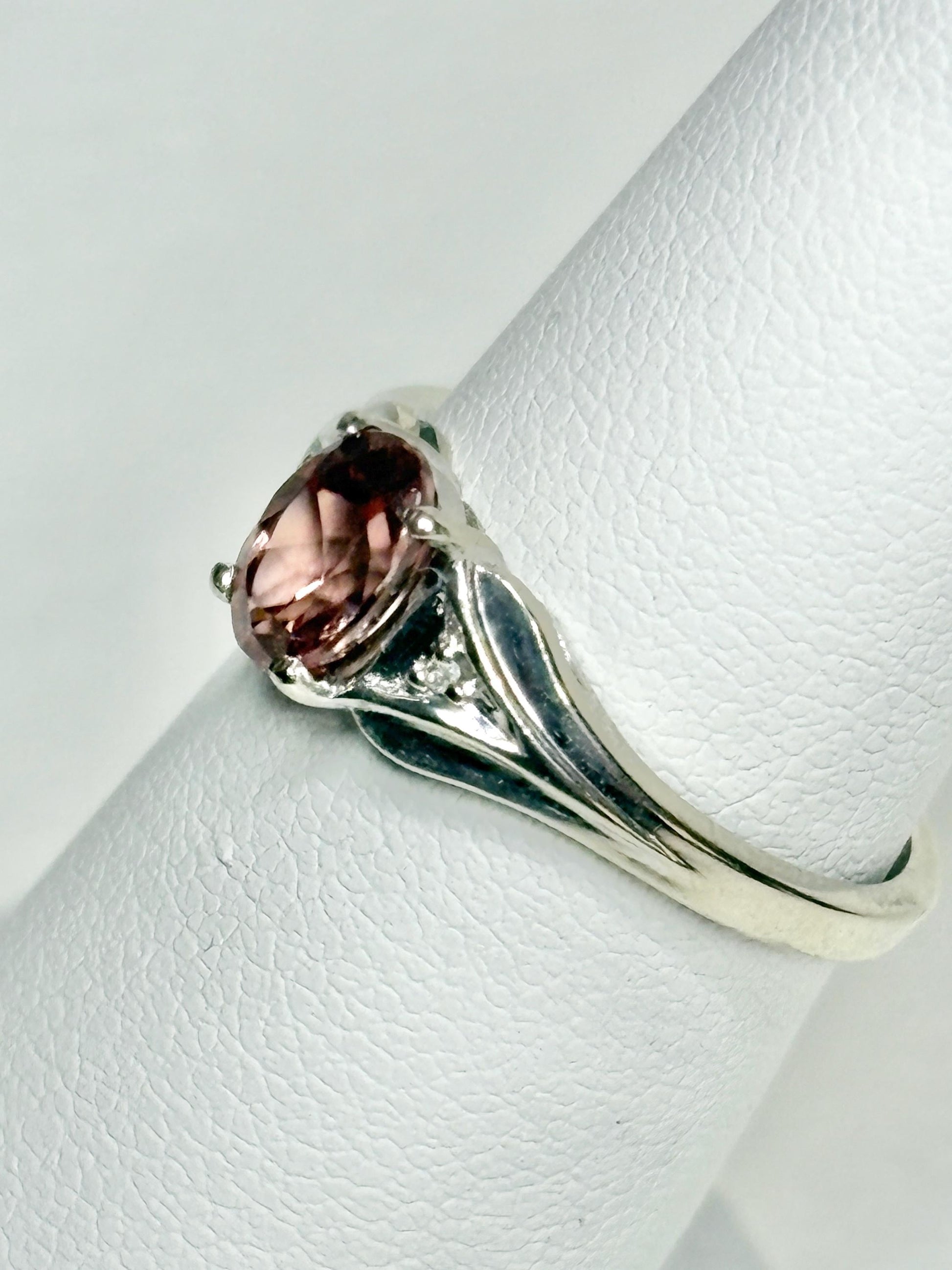 A 10k white gold ring with a blush pink zircon and diamond accents.