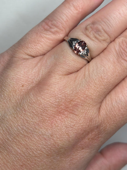 A blush pink zircon ring with diamond accents in 10k white gold.