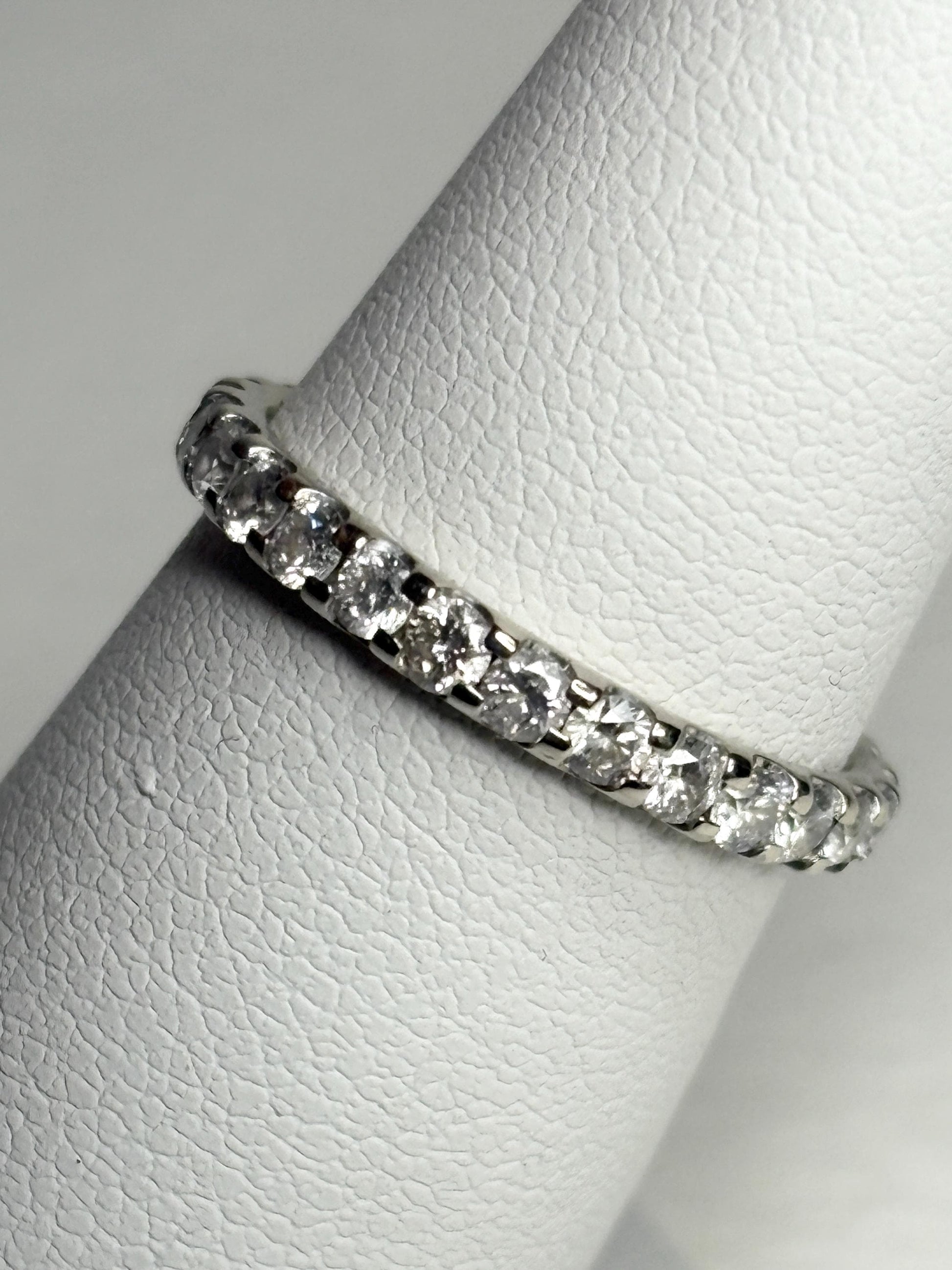 A 14k white gold full eternity band ring with 1ctw of diamonds.