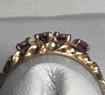 A 10k gold ring with four rhodolite garnets set in a rope band.